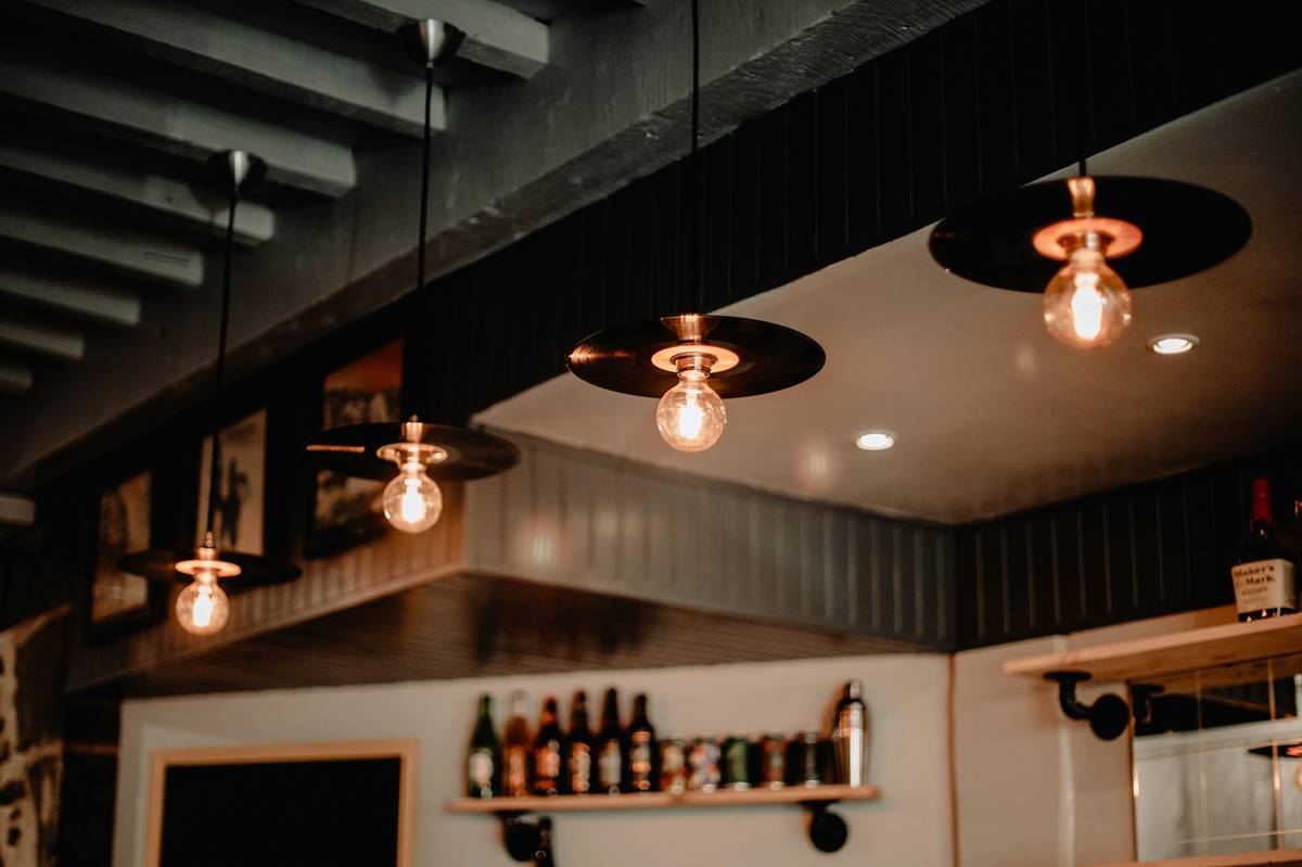 Elegant pendant light fixtures for restaurants illuminating a cozy dining table with warm ambient glow